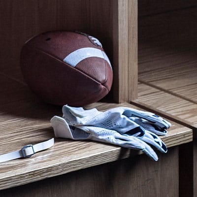 American football and gloves in changing room