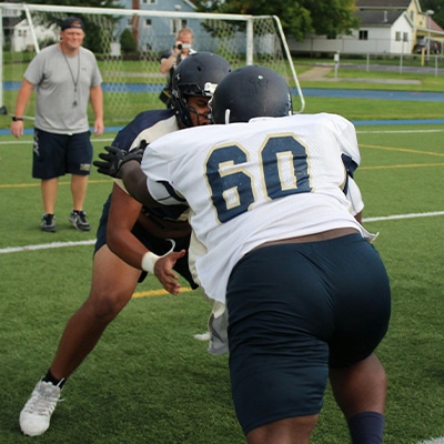 Players in training tackling each other wearing American Football Gloves